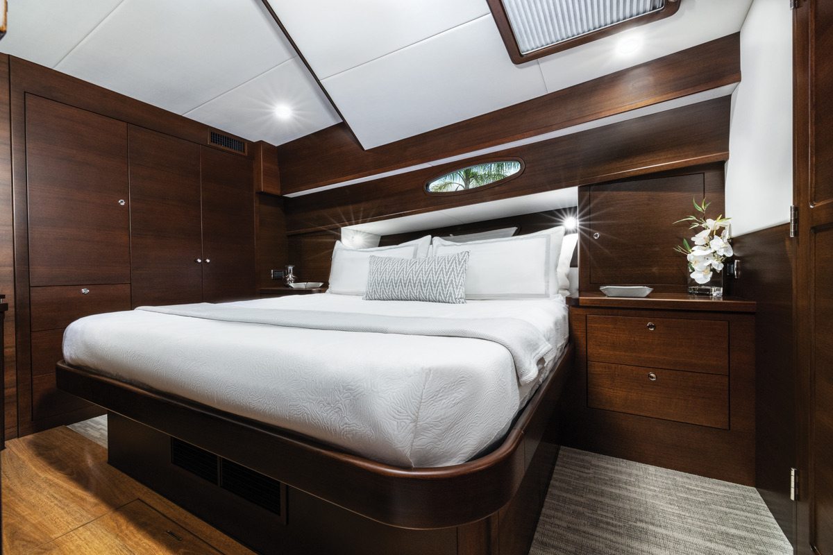 The master stateroom, amidships, with a king berth and dark-wood joinery. Photo: Courtesy Grand Banks